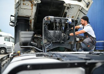 Man in uniform. Truck repair. Car malfunction.